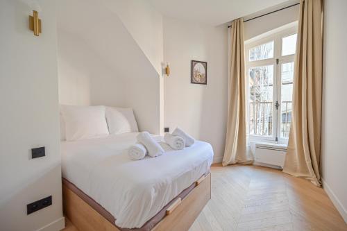 une chambre avec un lit avec deux serviettes dessus dans l'établissement Sumptuous & Serene Parisian Flat, à Paris