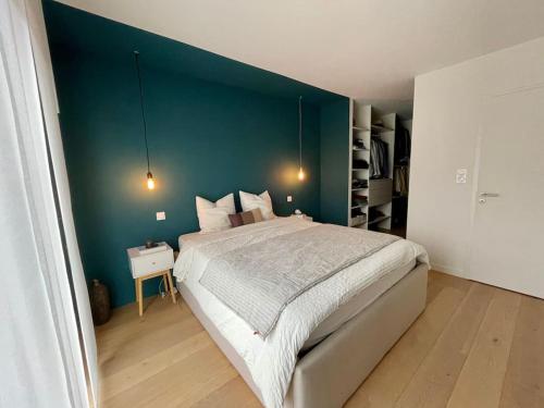 une chambre avec un grand lit et un mur bleu dans l'établissement Superbe villa familiale au calme, piscine, vue panoramique, entre mer et rivières, à Combaillaux