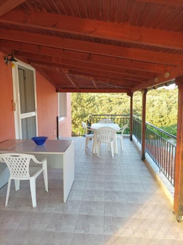 a patio with a table and chairs on a deck at Villa Fraoulitsa in Skoutarion