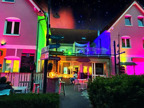 a group of buildings with colorful lights on them at feels Beach Club Hotel in Kühlungsborn