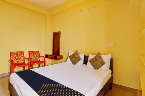 海得拉巴的住宿－OYO Hotel Akruthi Grand，一间卧室配有一张大床和两把椅子