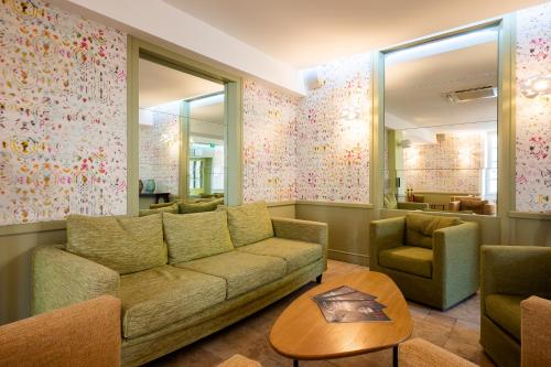 a living room with a couch and a table at Moulin de Vernègues Hôtel & Spa in Mallemort