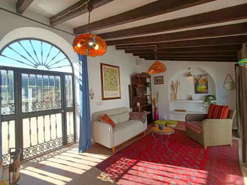 - un salon avec un canapé et une grande fenêtre dans l'établissement Beautiful House with Sea View and Nature, 30 minutes from Malaga, à Moclinejo