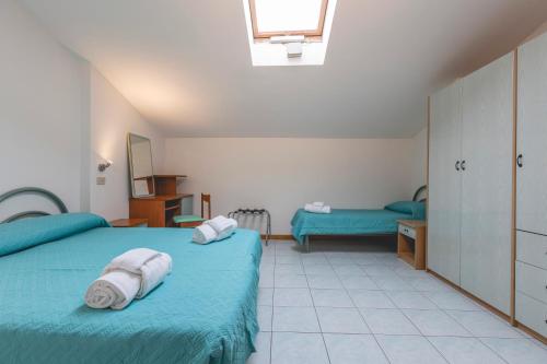 a bedroom with two beds with towels on them at Hotel La Perla in Cervia