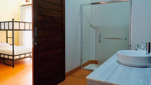 Vamana Bangsal في Pawenang: حمام مع حوض ودش زجاجي