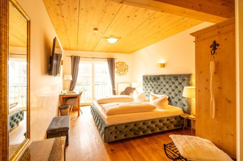 ein Schlafzimmer mit einem Bett und einem großen Fenster in der Unterkunft Landhaus Café Restaurant & Hotel in Wolfratshausen