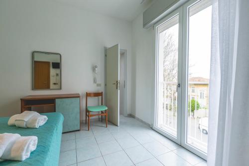 a bedroom with a bed and a large window at Hotel La Perla in Cervia