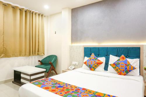 FabHotel Hari Kunj في فاراناسي: غرفه فندقيه بسرير وكرسي