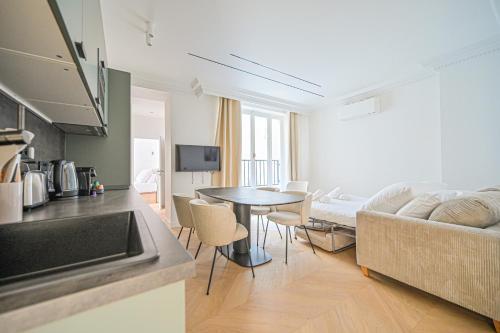une cuisine et un salon avec un canapé et une table dans l'établissement Sumptuous & Serene Parisian Flat, à Paris