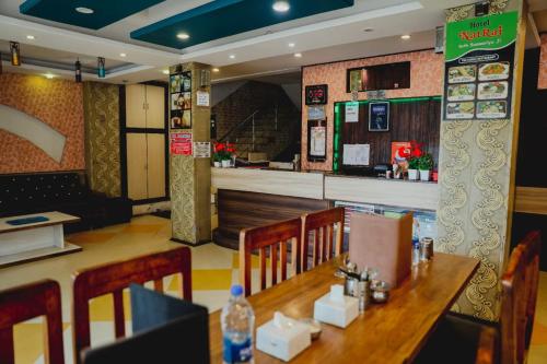 ein Restaurant mit einem Holztisch und einer Bar in der Unterkunft Hotel natraj pachmarhi in Pachmarhi