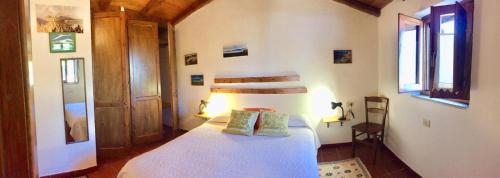 1 dormitorio con 1 cama blanca y 2 almohadas en Le Verande di Isola Rossa, en Isola Rossa