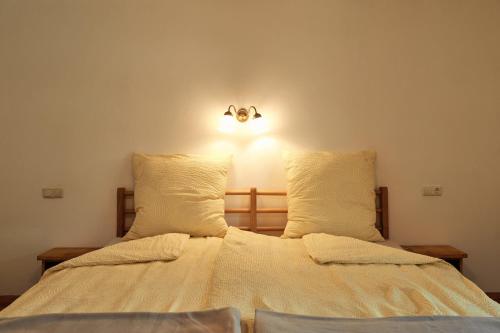 a bed with two pillows and a light on the wall at Beim Sattler in Peiting
