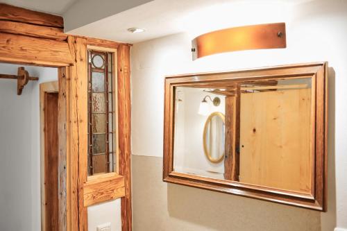 a bathroom with a mirror and a wooden cabinet at Beim Sattler in Peiting