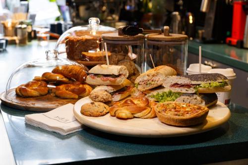 une assiette de sandwichs et de pâtisseries sur une table dans l'établissement Aparthotel Blend City Center, à Bucarest