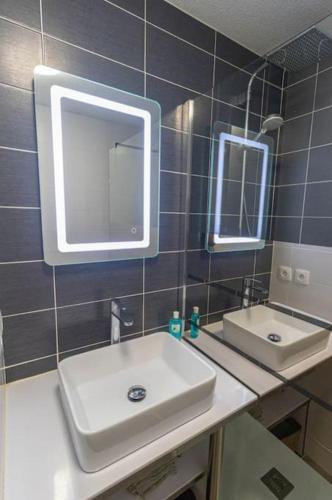 une salle de bain avec un lavabo et deux miroirs dans l'établissement *T3*Toulouse Purpan+Parking+Piscine, à Toulouse
