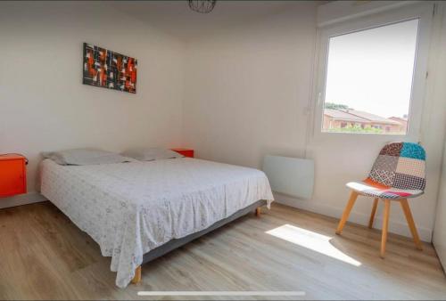 une chambre avec un lit, une chaise et une fenêtre dans l'établissement *T3*Toulouse Purpan+Parking+Piscine, à Toulouse