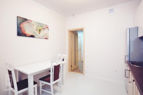 a white dining room with a table and a tv at Familion ApartHotel in Chişinău