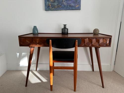 a wooden desk with a chair in a room at 1 Bedroom flat in Barons Court in London