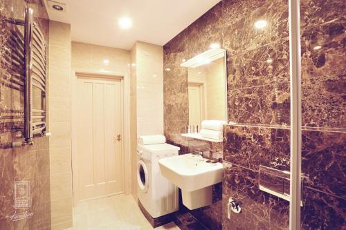 a bathroom with a toilet and a sink and a shower at Familion ApartHotel in Chişinău