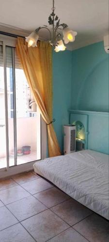 une chambre avec un lit et une grande fenêtre dans l'établissement Chambre privée dans un appartement de 4 chambres, à Toulon