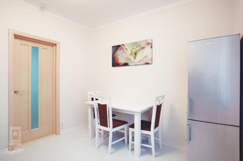 a kitchen with a white table and a refrigerator at Familion ApartHotel in Chişinău
