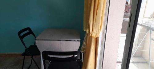 uma mesa e uma cadeira num quarto com uma janela em Chambre privée et climatisée dans un appartement de 4 chambres em Toulon
