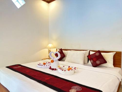 a bed with two bowls of food on it at Bupon house cempaka room in Penginyahan