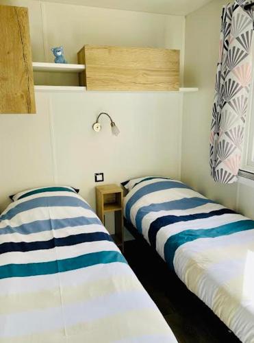 deux lits côte à côte dans une pièce dans l'établissement Mobil-Home 3 Chambres, TOUT CONFORT, Option 
