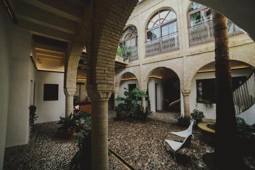 an indoor courtyard with chairs and plants in a building at Hotel Boutique Patio del Posadero in Córdoba