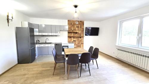 a kitchen and dining room with a table and chairs at Mazury Apartament/Dom z ogródkiem całoroczny przy jeziorze in Sędańsk