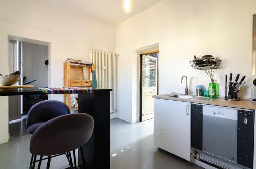 a kitchen with a counter and chairs in a room at Ostello Umile in Bologna