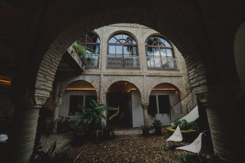 un arco con un edificio con ventanas y plantas en Hotel Boutique Patio del Posadero, en Córdoba