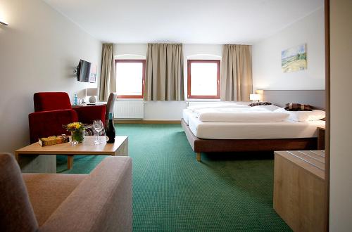 a hotel room with two beds and a couch at Gasthof Hillig in Bad Gottleuba