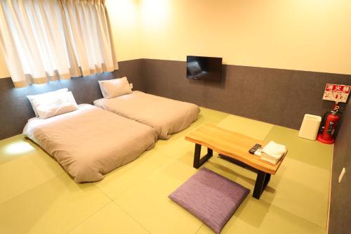 a hotel room with two beds and a table at KYOSTAY Iroha Komichi in Kyoto