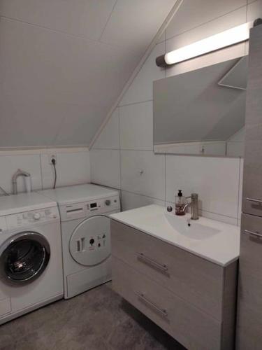 a bathroom with a washing machine and a sink at Russelv panorama in Russelv