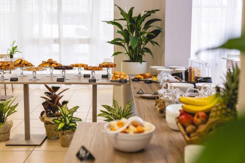 a buffet of food on a table with fruit at Hotel La Perla in Cervia