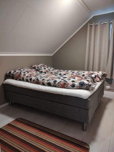 a bed in a bedroom with a flowery bedsheet at Russelv panorama in Russelv