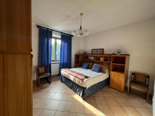 1 dormitorio con 1 cama y 1 silla en Casa vacanze Monte, en Castellino Tanaro