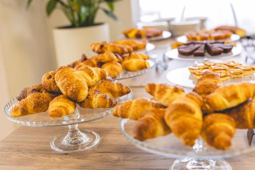 a table topped with plates of pastries and pastriesearcher at Hotel La Perla in Cervia