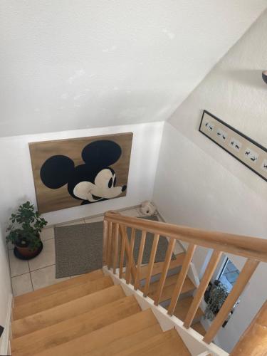a room with stairs and a painting of a mickey mouse at Caros Zimmer Gladbeck in Gladbeck