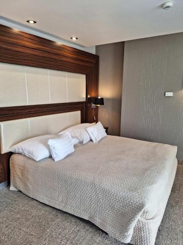 a bedroom with a large bed with white pillows at Duna Garden Hotel in Budapest