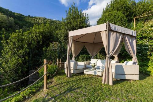 un cenador con muebles blancos en un patio en The Villa Suites - Pool & SPA, en Como