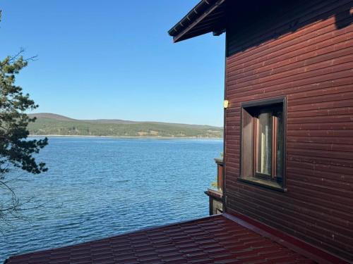 a building with a view of a large body of water at Villa Iskar Lake in Shtarkelovo Gnezdo