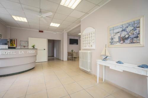 a lobby of a hotel la revival with a reception desk at Hotel La Perla in Cervia