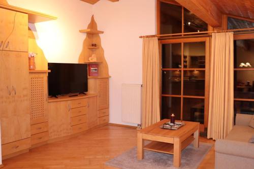 a living room with a tv and a coffee table at Zum Eichhof in Reit im Winkl