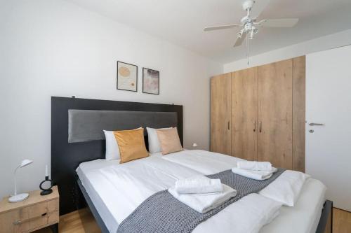ein Schlafzimmer mit einem großen Bett mit zwei Handtüchern darauf in der Unterkunft HM • Stylish 1BR Escape, City Quick in Wien