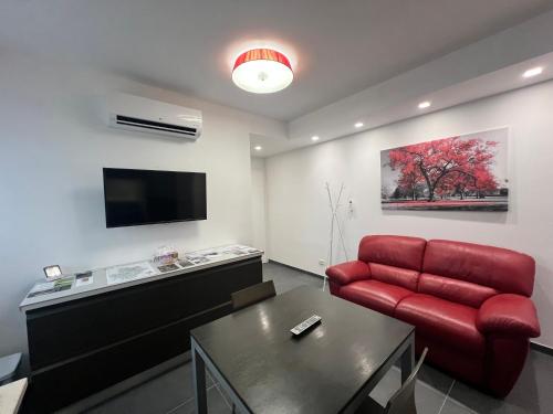 een woonkamer met een rode bank en een tafel bij Peonia and Mughetto apartments in the Langhe in Albaretto Della Torre 