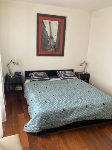 - une chambre avec un lit et une photo de la tour Eiffel dans l'établissement Spécial jeux olympiques, à Levallois-Perret