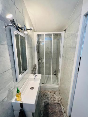 une salle de bain avec un lavabo blanc et une douche dans l'établissement Le Grenier, à Sospel