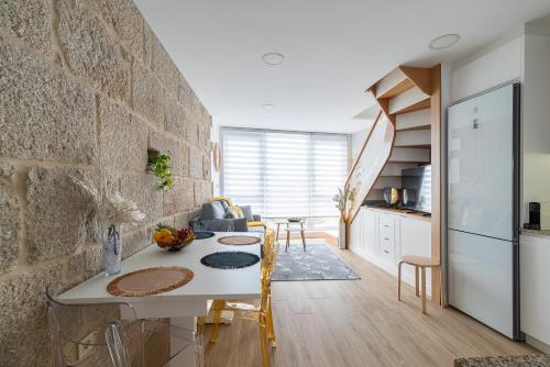 uma cozinha com uma mesa e uma parede de pedra em Apartamento Almuiña em Marín